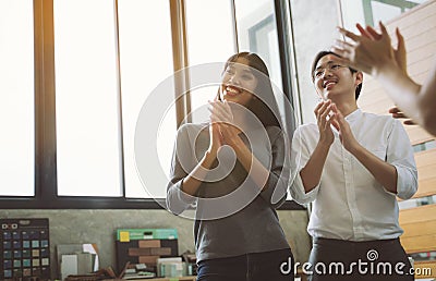 Young Asian creative business people clapping hands at the meeting Stock Photo