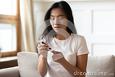 Asian woman measure blood sugar level with glucometer Stock Photo