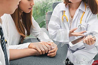 Young Asian doctor consulting patient in hospital office. Health care and medical concept. Encouragement and empathy Stock Photo