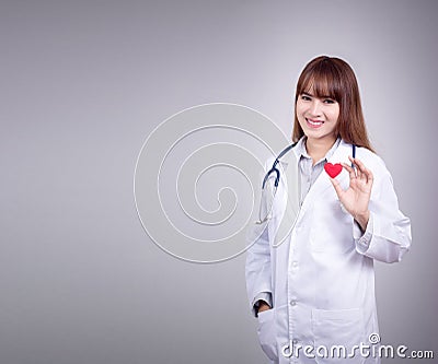 Young Asian doctor stand holding a red heart in her hand Stock Photo