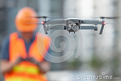 Young Asian engineer flying drone over construction site Stock Photo