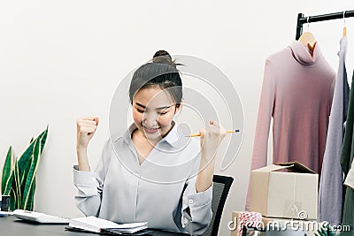 Young asian entrepreneurs are acting of joy as they sell their clothes on target Stock Photo