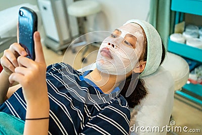 Young Asian female teenager getting her acne and facial treatment Stock Photo