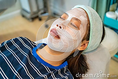 Young Asian female teenager getting her acne and facial treatment Stock Photo