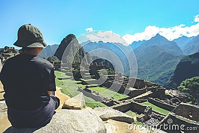 A young asian female traveler is admiring the Inca ruins of Machu Picchu, one of the New Seven Wonder of The World. Editorial Stock Photo