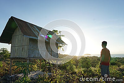 Young man reach to the top of hill then enjoy the sunrise from the top Stock Photo