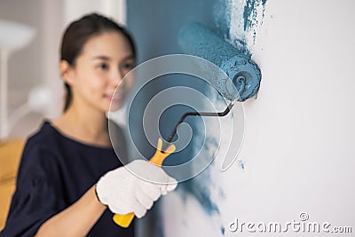 Young asian happy woman painting interior wall Stock Photo