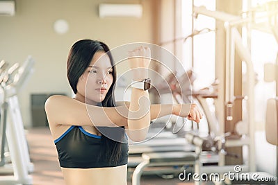 Young Asian healthy woman doing arm muscle stretching, warm up before exercising Stock Photo