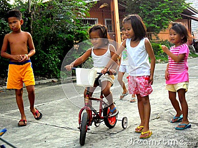Young asian kids playing and riding a bike Editorial Stock Photo