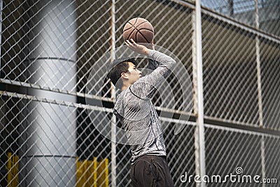 Asian young basketball player taking a jump shot Stock Photo