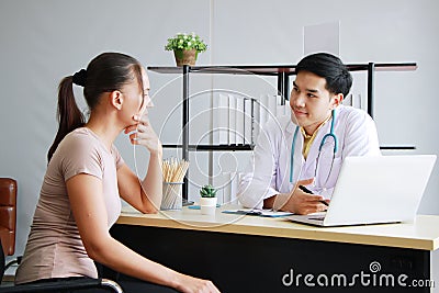 Young Asian male psychiatrist is specialist in psychiatry Caucasain female Patient is smiling together for therapy and talking. Stock Photo