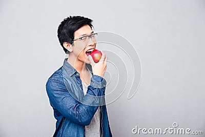 Young asian man bitting red apple Stock Photo