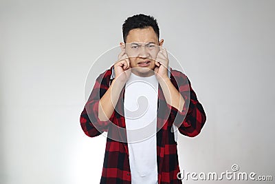 Young Asian man closing his ears dont want or avoiding to hear bad news, stress under mental pressure Stock Photo