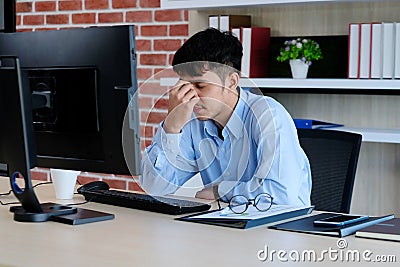 Young asian man with frustrated expression while working with computer at office desk, office lifestyle Stock Photo