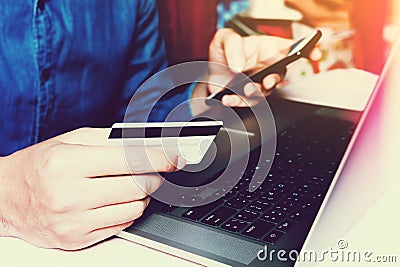 Young asian man holding card and smartphone using search for dat Stock Photo