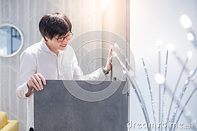 Young Asian man opening modern wardrobe choosing furniture in wa Stock Photo