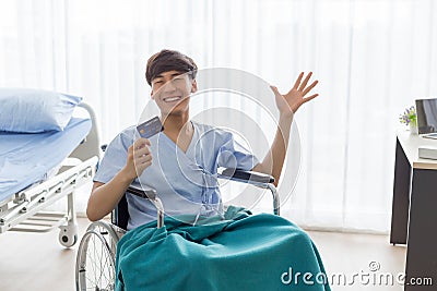 Young Asian man patient showing mock up credit card at the hospital Stock Photo