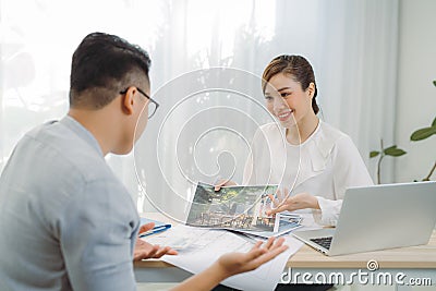 Young Asian man at real estate agent in office with famale seller Stock Photo