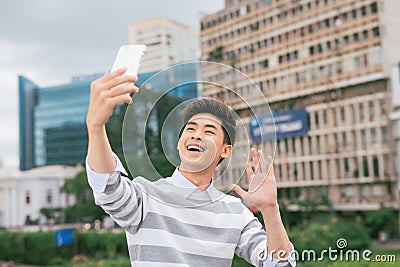 Young Asian man taking selfie on the background of city Stock Photo