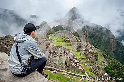 Young Asian man traveler looking at Machu Picchu Stock Photo