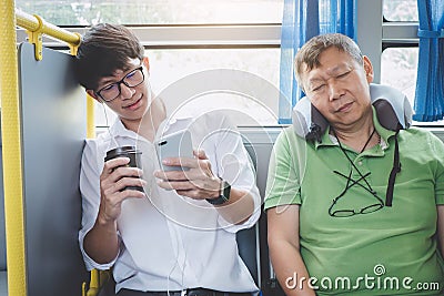 Young Asian man traveler sitting on a bus using smartphone for l Stock Photo