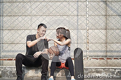 Young asian man and woman bumping fists outdoors Stock Photo