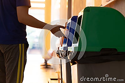 Young Asian men dump cans or plastic bottles in sorting bins for recycling Editorial Stock Photo