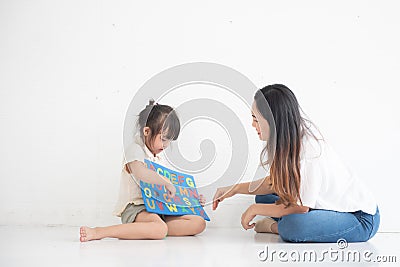 Young Asian mother taught her little daughter about reading English characters, family concept Stock Photo