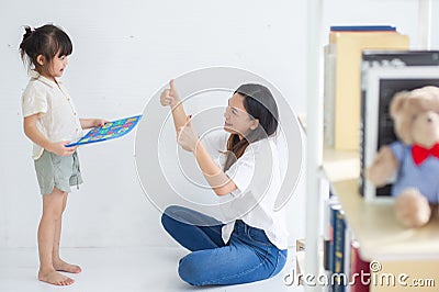 Young Asian mother taught her little daughter about reading English characters, family concept Stock Photo