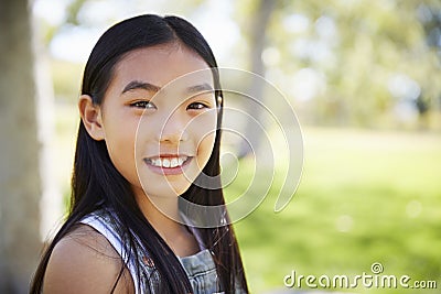 Young Asian schoolgirl smiling to camera, close up Stock Photo