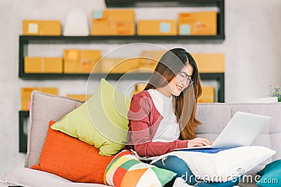 Young Asian small business owner working on laptop computer at home Stock Photo