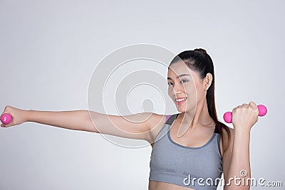 Young asian sporting woman training with dumbbell. Pretty athletic girl making physical exercise against white background. Health Stock Photo