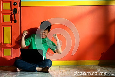 Young asian teen with a laptop computer in a living room Stock Photo