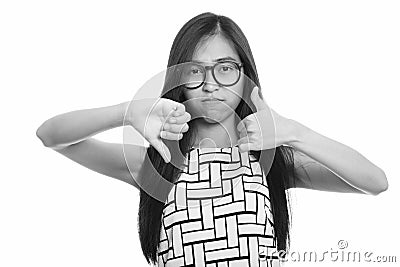 Young Asian teenage nerd girl giving thumbs up and down Stock Photo