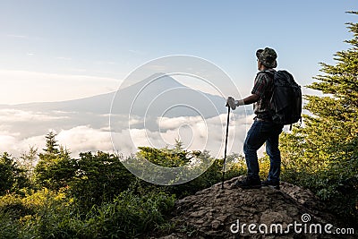 Young Asian tourist trekking to the top for seeing Mount Fuji Stock Photo