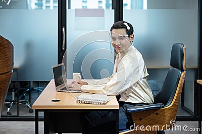 Young asian transvestite office worker working with laptop and document at desk in the office Stock Photo
