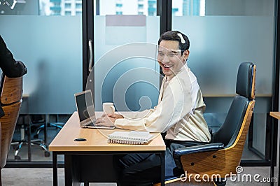 Young asian transvestite office worker working with laptop and document at desk in the office Stock Photo