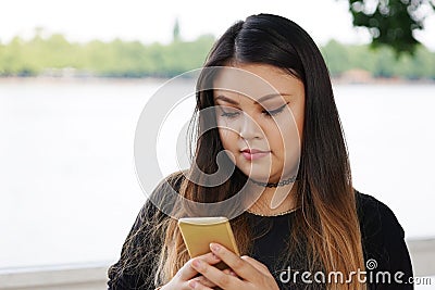 Young asian woman checking her smartphone Stock Photo