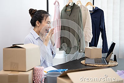 Young Asian woman congratulated and smiled as a large number of customers ordered her clothes online, Business of selling clothes Stock Photo