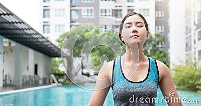 Young asian woman doing yoga moves or meditating by the pool, Stock Photo