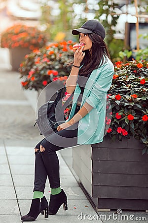 Young asian woman eating fast food outdoors Stock Photo