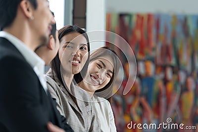 Young asian woman freshman joined the group of young entrepreneurs with three seniors on the team Stock Photo