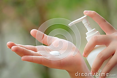 Young Asian Woman hands holding body lotion bottle and using cream for treatment skin in winter time. Stock Photo