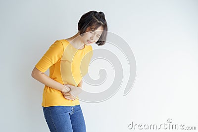 Young asian woman having painful stomachache on white background.Chronic gastritis. Abdomen bloating concept Stock Photo