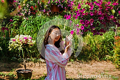 Young asian woman is holding flowers in the garden in the spring. Stock Photo