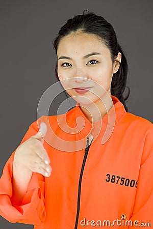 Young Asian woman offering hand for handshake in prisoners uniform Stock Photo