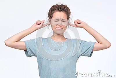 Woman plugging ears, pretending not to hear what she is told. Stock Photo
