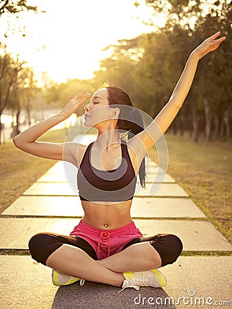 Young asian woman practicing yoga outdoors at sunset Stock Photo