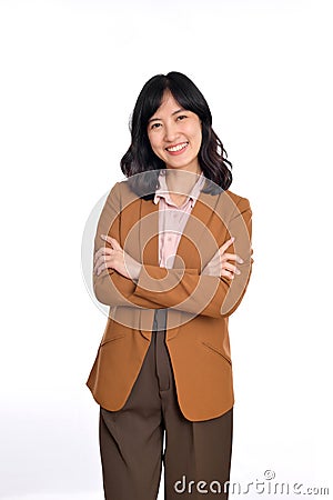 Young asian woman, professional businness entrepreneur in brown suit with arms crossed and smile isolated over white background Stock Photo