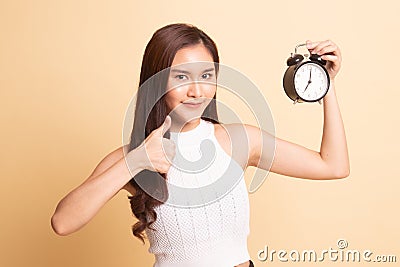 Young Asian woman show thumbs up with a clock Stock Photo